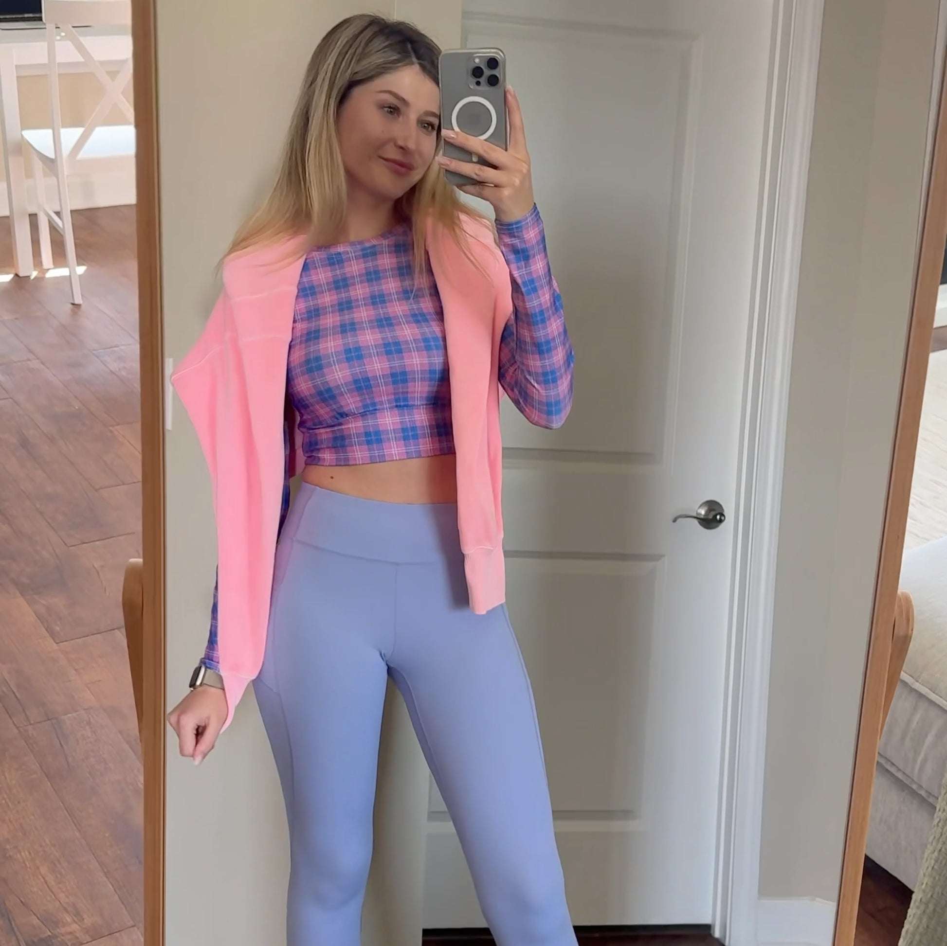 Woman wearing a pink and periwinkle long sleeve crop top for workout