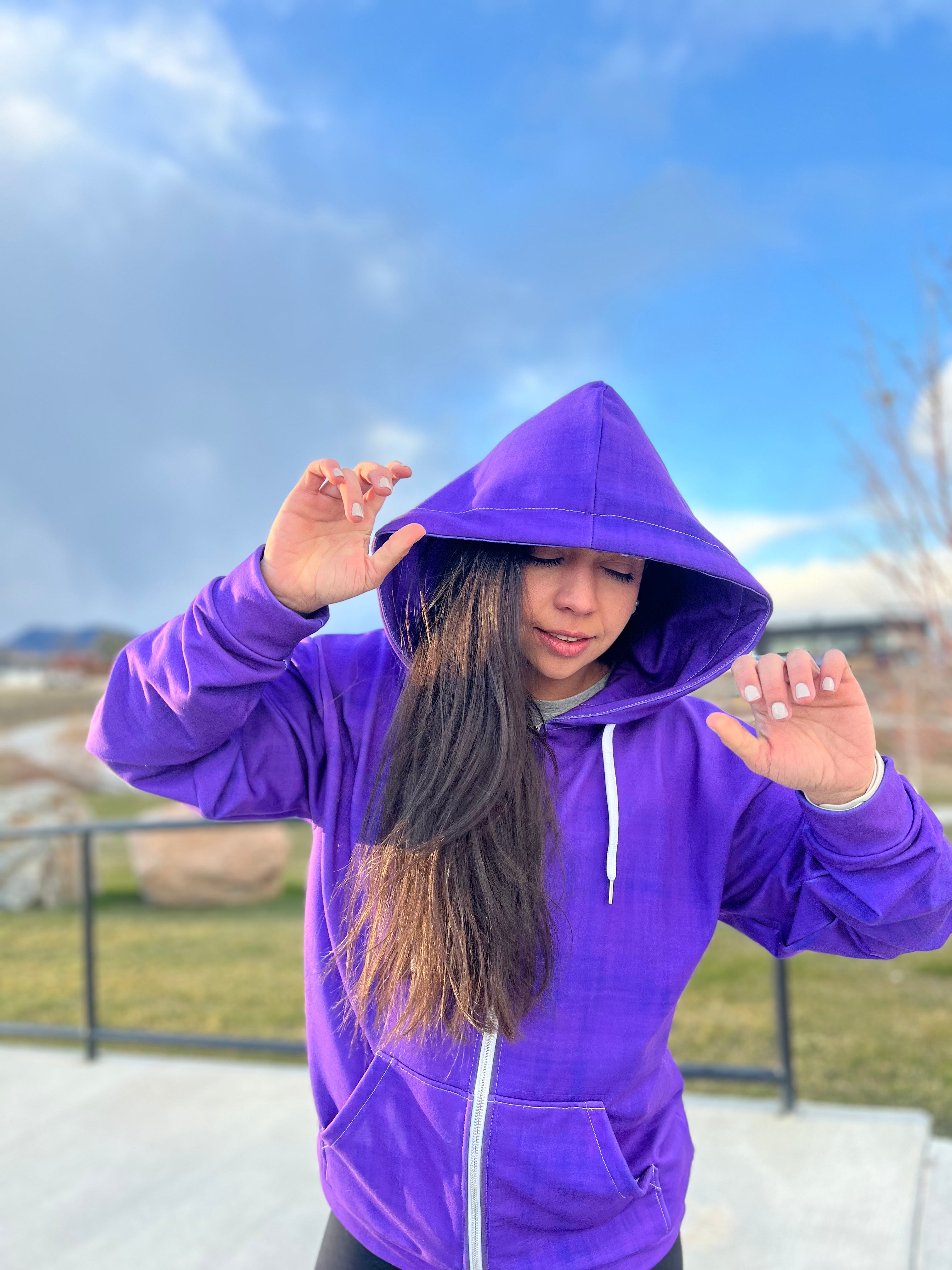 How to wear bold colors: Joyful woman hiking with a colorful purple pop zip hoodie