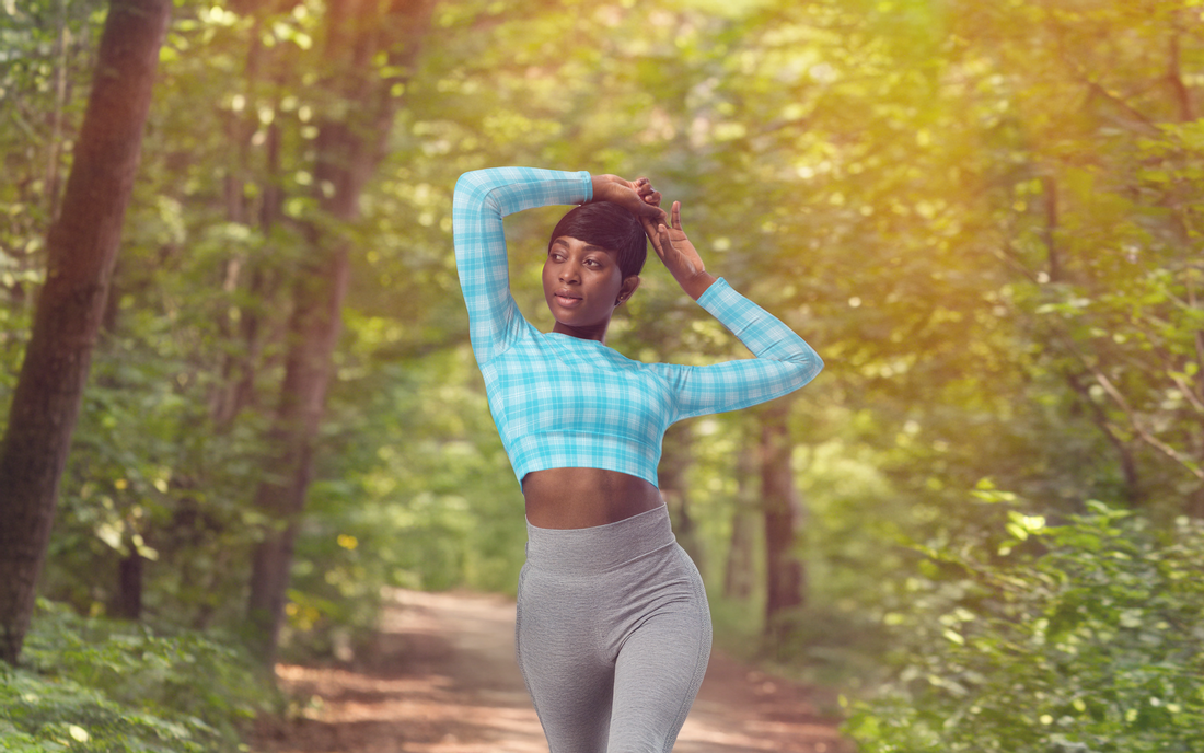 Women in Electric Blue Recycled Long Sleeve Crop Top doing Yoga on a trail in the wood