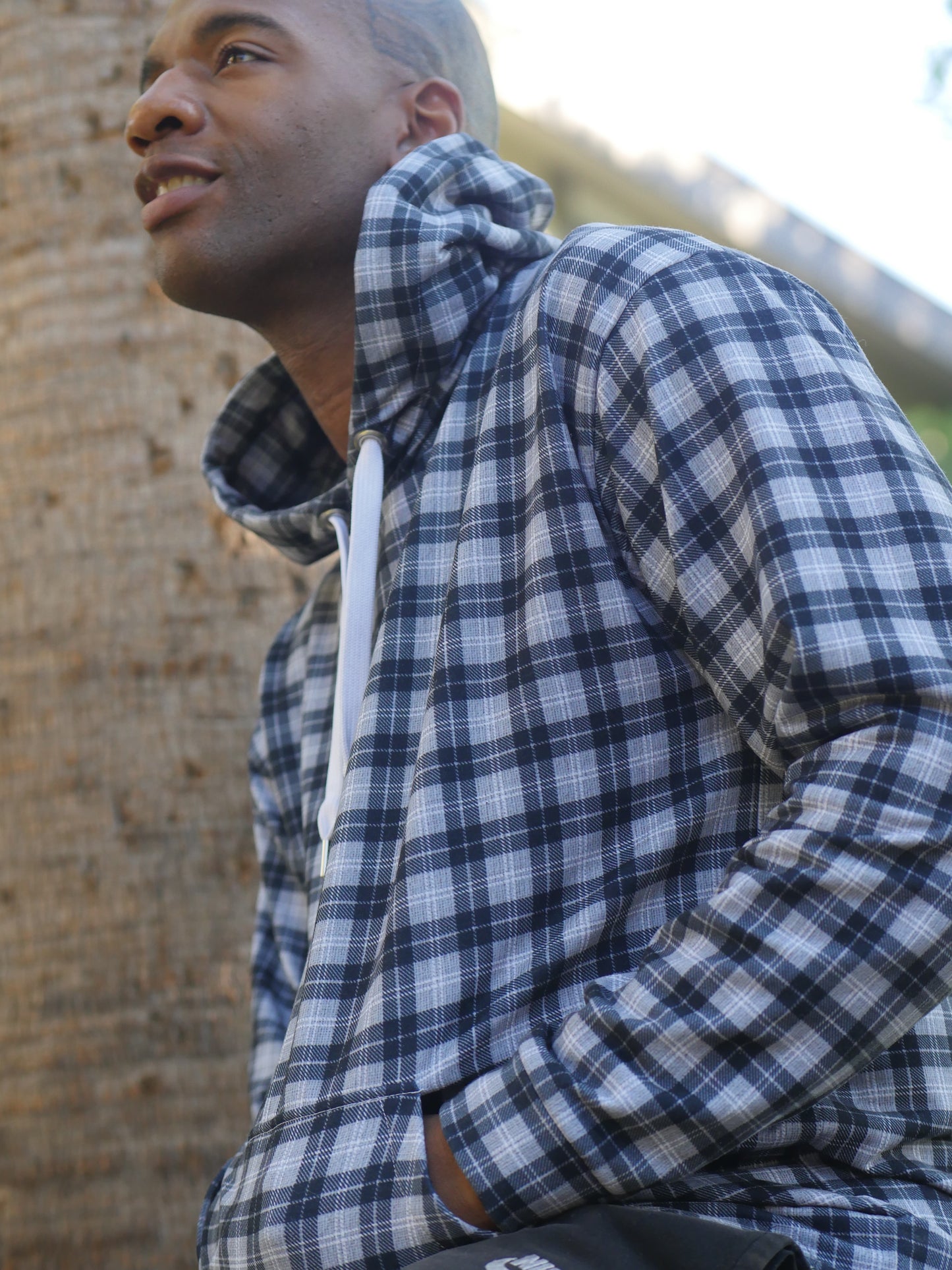 Man wearing a black and white plaid hoodie with drawstrings