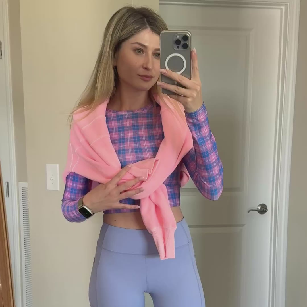 Woman wearing a pink and periwinkle long sleeve crop top for workout